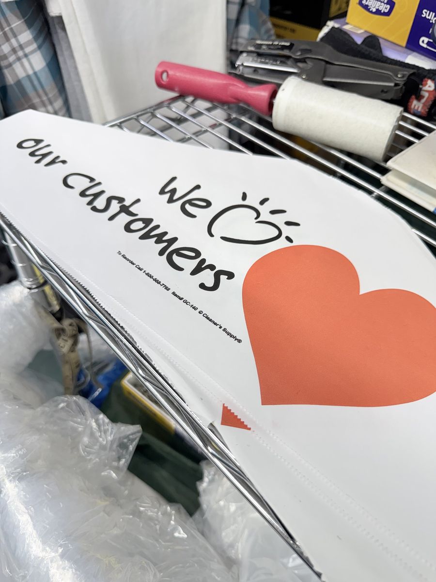 Finished garments in Sunflower Cleaners covers printed with We Love Our Customers